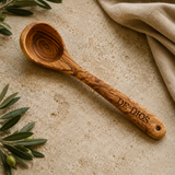 Olive wood ladle engraved with a sample family name on the handle, a personalized kitchen gift