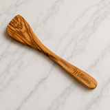 Olive wood spatula engraved with a sample name along the handle, a personalized cooking gift