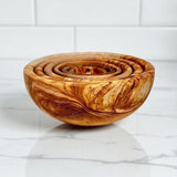 Olive wood nesting bowl set of 6 stacked inside each other on a white counter