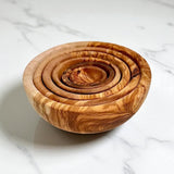 Nested olive wood bowls from above showing all six rims and the swirling grain