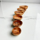 Row of six olive wood bowls in graduated sizes, handmade pinch and snack bowls