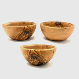 Three olive wood pinch bowls from the side showing their rounded shape and dark grain