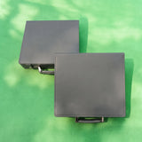 Two plain gray leather 100 chip poker set cases on green felt, ready for engraving