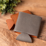 Grey vegan leather drink holder, flat view of the stitched edges and fold out base, blank front