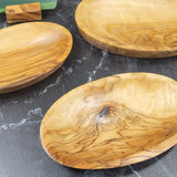 Three empty oval olive wood trays in small, medium and large showing the grain