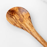 Close-up of the bowl of a handmade olive wood cooking spoon showing the swirling grain