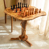 Full view of the rustic olive wood chess table with branch legs in a sunny living room