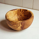Round olive wood bowl with deep sides and bold dark grain, a handmade serving bowl