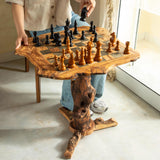 Handmade olive wood chess table with a rustic natural edge top and tree branch base, pieces set up