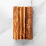 Top view of an olive wood soap saver tray showing the ridged surface and grain