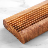 Close-up of the carved ridges and rounded ends of a natural olive wood soap dish