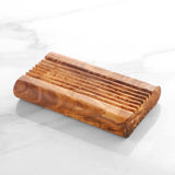 Handmade olive wood soap dish on white marble, a natural bathroom accessory