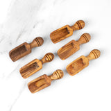Six rustic olive wood spice scoops lined up from small to large, pantry spoons with ridged handles