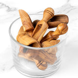 Glass bowl filled with handmade olive wood spice scoops of different sizes